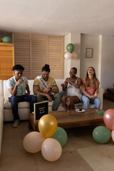 Celebrating new job, diverse friends laughing and enjoying party at home