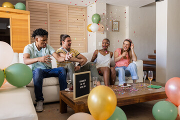Celebrating with confetti and balloons, friends having joyful moments together indoors