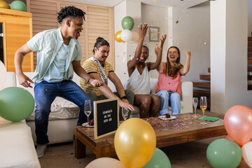 Friends celebrating new job with confetti and balloons in living room