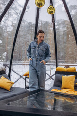 A woman is relaxing inside a domed tent at a glamping in the forest
