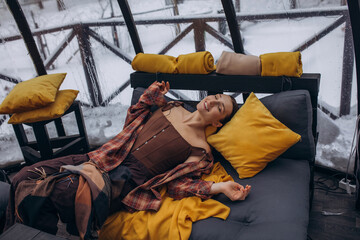 A woman is relaxing inside a domed tent at a glamping in the forest