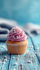 Pink frosted cupcake on teal wood (1)