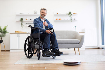Middle-aged man using robot vacuum cleaner in living room. Clean, organized environment supports assistive lifestyle showcasing independence and technology.