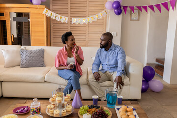 Couple enjoying snacks and conversation at home during festive celebration