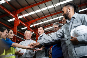 A group of people are high fiving each other in a factory