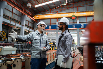 Two men in a factory discussing something