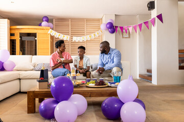 Family celebrating birthday at home with balloons, gifts, and joyful conversation
