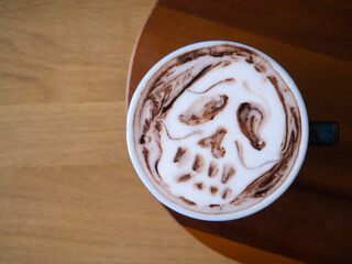 coffee latte art brown white cappuccino drink cup hot beverage espresso milk foam cafe breakfast caffeine barista design halloween sugar skull dead horror death wooden table background selected focus