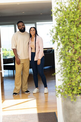 Smiling couple standing together at home, enjoying sunny day indoors