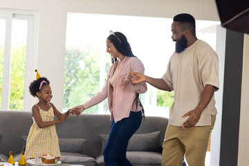 Family enjoying playful dance together at home, celebrating with joy and laughter