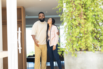 Couple standing together at home, sharing loving moment by doorway
