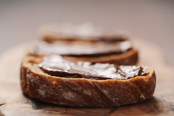Ciabatta slices with chocolate spread on olive wood board
