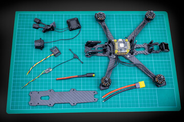 Building a racing drone with all components separated on a mat. The quadcopter is ready to be assembled 