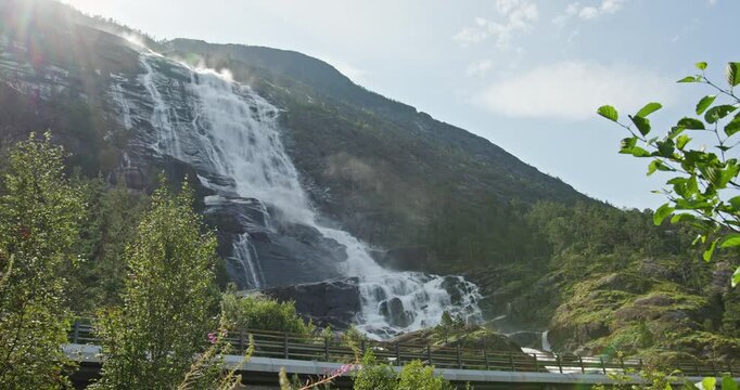 Langfossen Waterfall and Road Bridge in Akrafjorden, Norway, with Passing Truck on a Sunny Summer Day