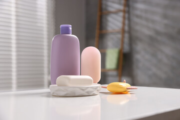 Baby accessories and bathing products on white table in bathroom