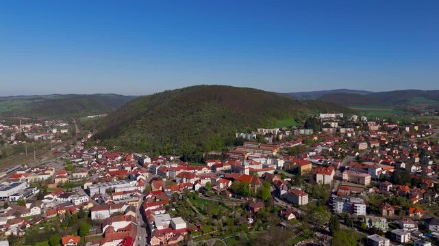 Aerial drone view flying over the residential town of Tisnov, showcasing the lush green landscape of Boskovice Furrow in South Moravia, Czechia.