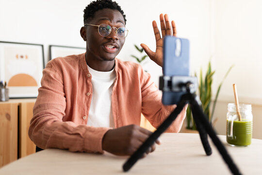 Young man greeting during a video call on smartphone at home