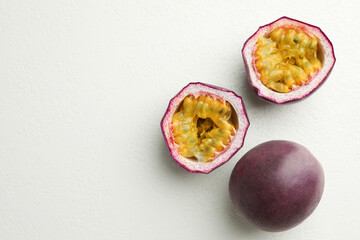 Fresh passion fruits on white table, flat lay. Space for text