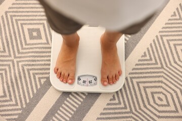 Little boy standing on scales indoors, top view