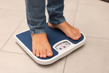 Little boy standing on scales indoors, closeup