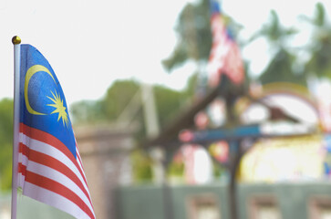 A respectful and patriotic image of the Malaysian flag in the foreground, ideal for content related...