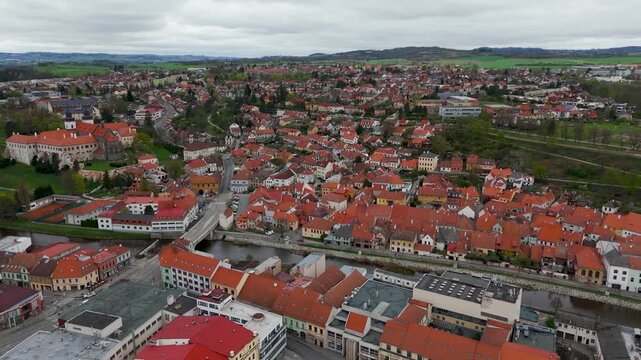 Cinematic drone shot flying into the historic town of Trebic, Czechia, revealing the St. Procopius Basilica, Jihlava River, and UNESCO Jewish Quarter.