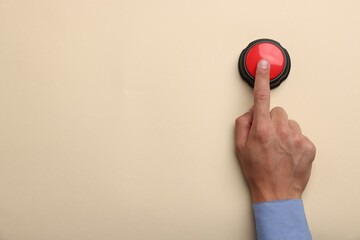 Man pressing button on beige background, top view. Space for text