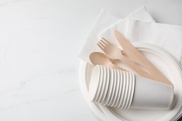 Set of disposable tableware on white background, top view. Space for text