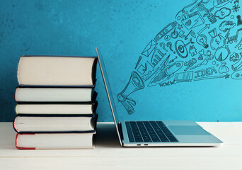 Laptop spreading marketing ideas from books with megaphone sketch