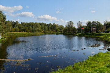 Obraz premium A Beautiful and Serene Lake Surrounded by Lush Greenery Under a Stunning Blue Sky Above