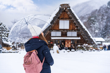 Young woman traveler enjoying with snow at shirakawa-go in winter