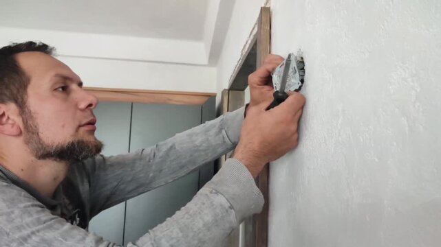 Professional Electrician Installing a Wall-Mounted Electrical Switch in a Residential or Commercial Building to Ensure Safe and Efficient Power Control According to Modern Electrical Standards and Saf
