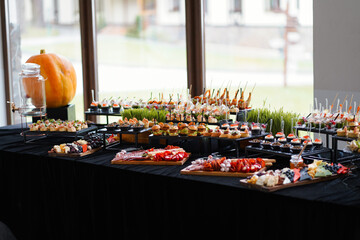 Cheese platter with colorful cheese varieties, fruits, nuts, and honey.