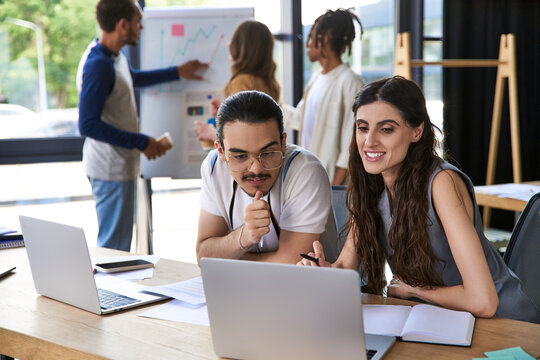 Creative young coworkers collaborate in a bright office environment to achieve their goals - Powered by Adobe
