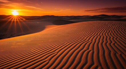 Naklejka premium Vivid desert landscape bathed in sunset's golden light, highlighting intricate sand dune patterns under a fiery sky
