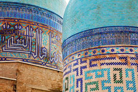 Historic architecture with beautiful domes and colorful mosaic tiles in Samarkand, Uzbekistan. Shah-i-Zinda, In old arabic God is great on the walls.