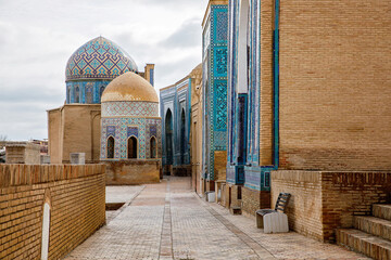 Historic architecture with beautiful domes and colorful mosaic tiles in Samarkand, Uzbekistan. Shah-i-Zinda, In old arabic God is great on the walls.