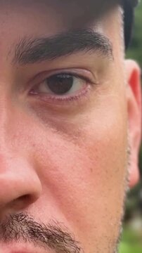 The man's eye twitches. Nervous tension. Close up footage vertical banner