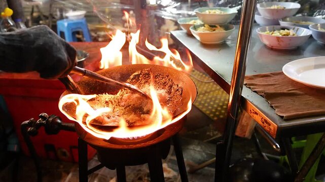 Street Food Chef Stir-Frying Over Open Flame in Bangkok