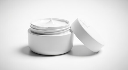 A white jar of cream with its lid next to it, on a seamless white backdrop, showcasing a smooth, textured surface