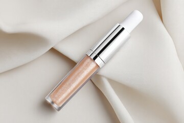 Fototapeta premium Creamy, shimmering lip gloss on draped fabric