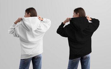 Mockup of white, black oversized hoodie, casual wear on a girl in blue jeans, back view, isolated on background.
