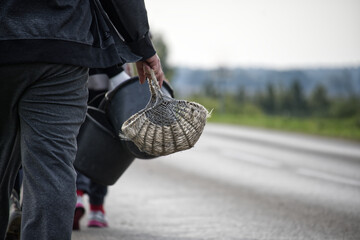 People carrying baskets and buckets on a road after harvesting potatoes.