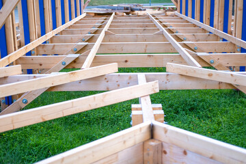 Structural wooden beams forming frame commercial building under construction in natural light,...