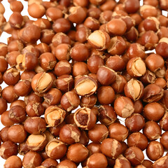 Obraz premium A detailed close-up shot of a pile of roasted hazelnuts, showcasing their rich brown color and textured shells, perfect for culinary use and healthy snacking