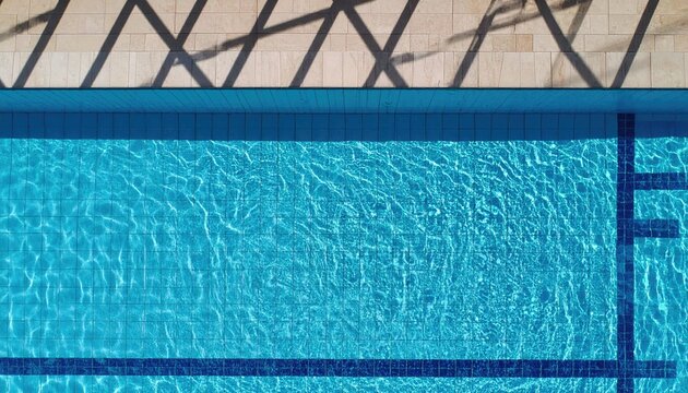 Overhead View of a Blue Swimming Pool with Sunlight Reflections