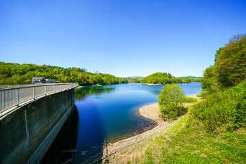 Fototapeta premium View of the Aggertalsperre Dam in the Oberbergisches Land region of North Rhine-Westphalia. A lakeside landscape with the surrounding nature. 