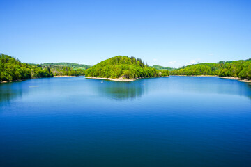 View of the Aggertalsperre Dam in the Oberbergisches Land region of North Rhine-Westphalia. A lakeside landscape with the surrounding nature.
