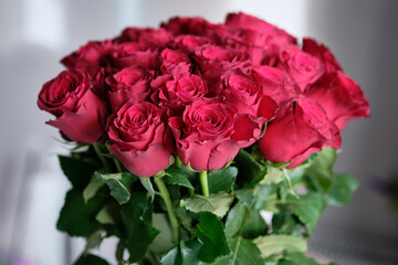 A stunning cluster of red roses showcases their deep color and delicate petals, filling the indoor space with elegance and a fragrant aroma, perfect for celebrations