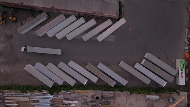Aerial view of freight trailers with one being moved out of the diagonal rows: a scene of logistics and transport infrastructure with geometric patterns. Appleton, Wisconsin, United States.